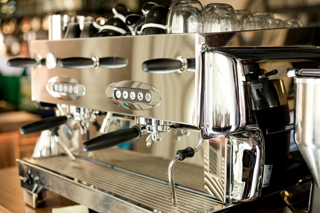 A sleek and modern stainless steel coffee machine in a contemporary cafe setting.